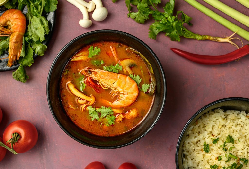 Bol de soupe thaïlandaise, tom yam et qui est a base de crevettes avec des légumes autour pour ajouter de l’esthétique à l’image 