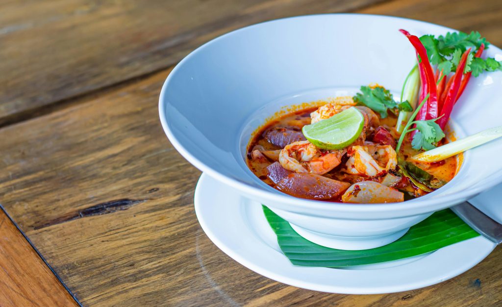 Un bol de soupe thaïlandaise, tom yam avec des assortiments de piments rouge, de citron vert et de ciboulette