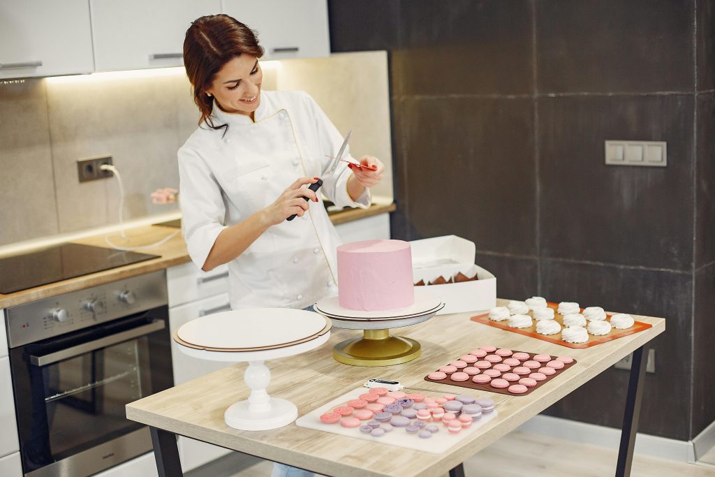 chef cuisinière qui décors un gateaux
