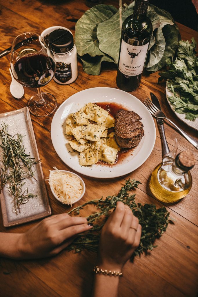 plat de ravioli fait maison accompagnée d'un verre de vin 