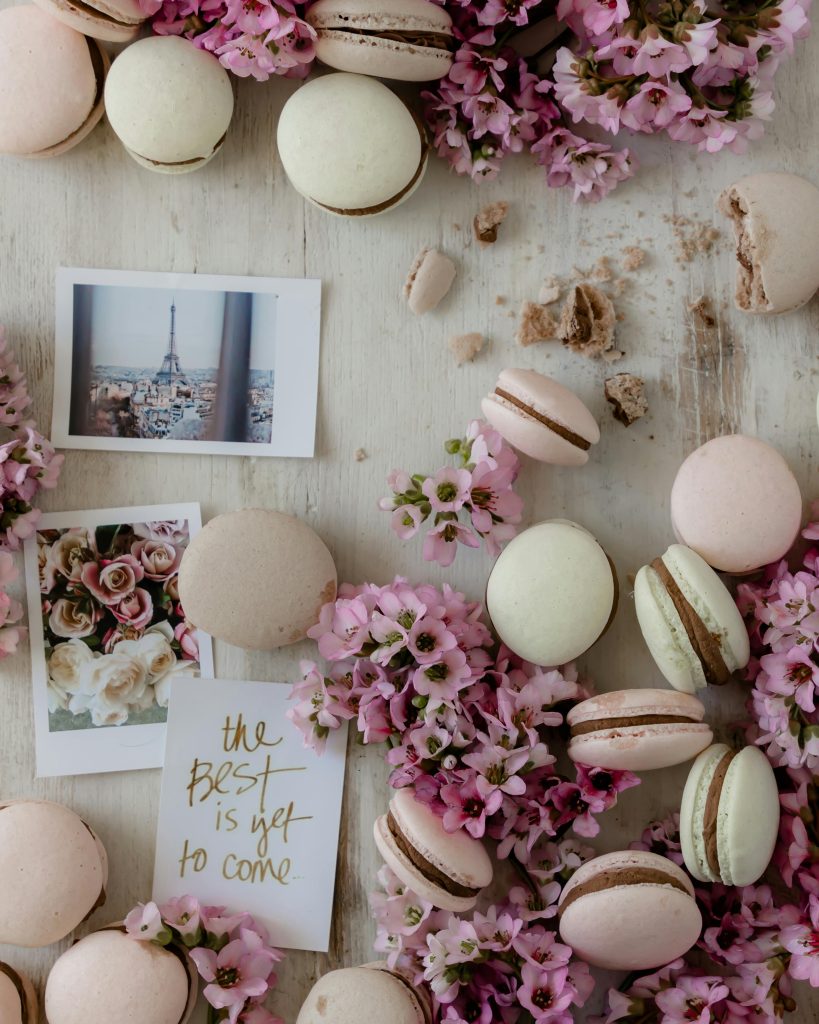 Image de macarons déposés sur une table avec dees images et des fleures